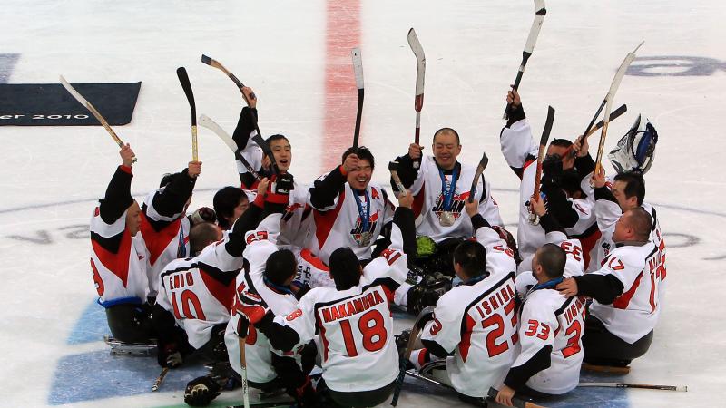 A picture of men playing sledge hockey celebrating their victory