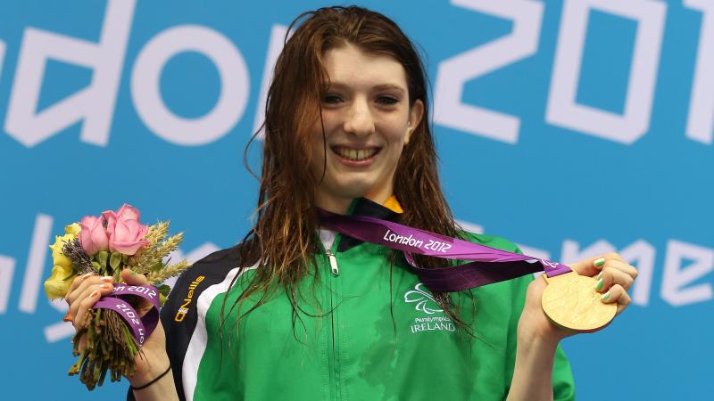 A picture of a woman showing her gold medal