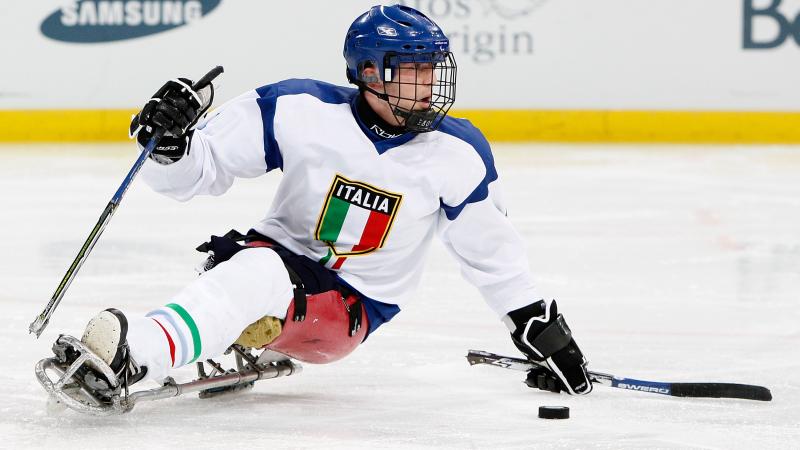 A picture of a man in a sledge practising Ice Sledge Hockey.