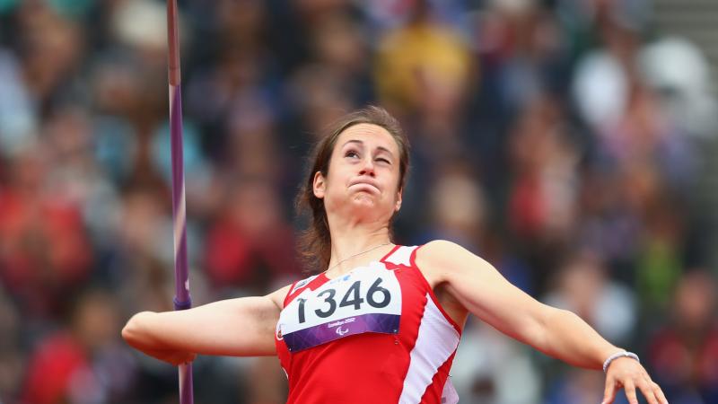 A picture of a woman in the field throwing the Javelin