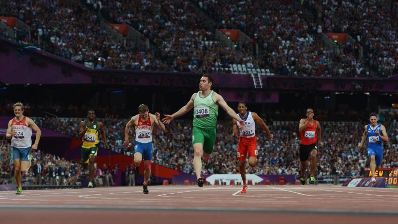 A picture of a man on a track crossing a finishing line