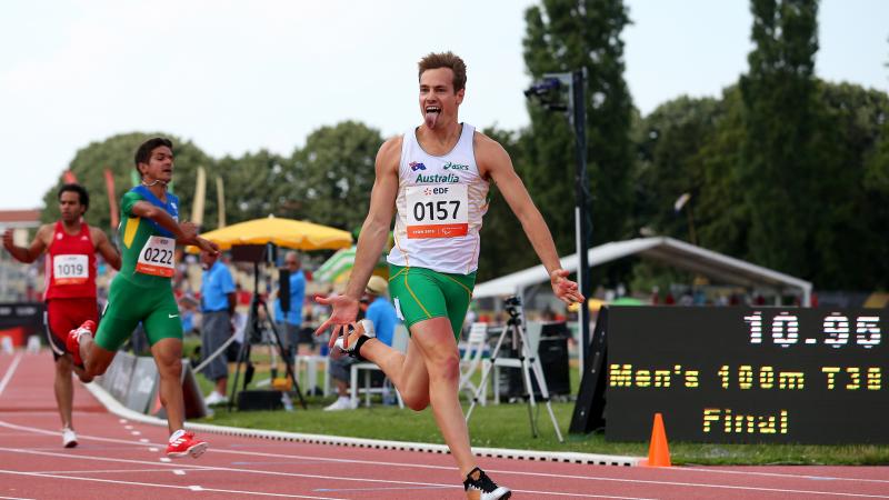Man crossing a finish line in a stadium, celebrating