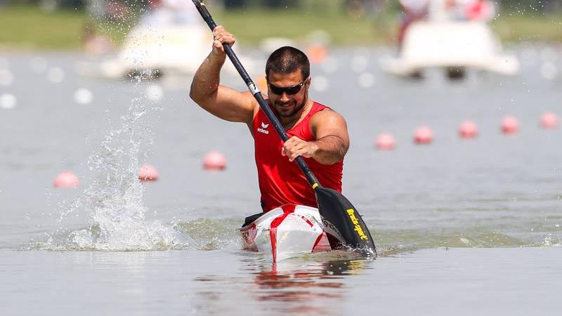 A man paddles in a canoe.