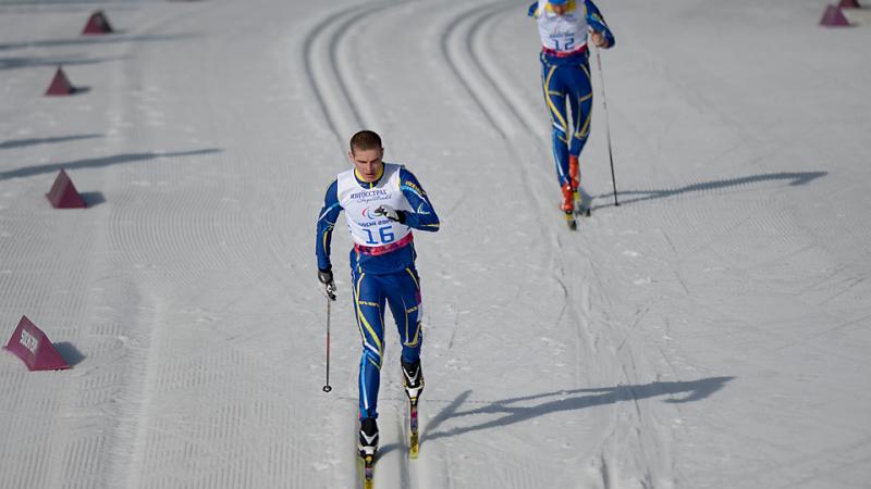Ukrainian Ihor Reptyukh skis at Sochi 2014 followed closely by a competitor
