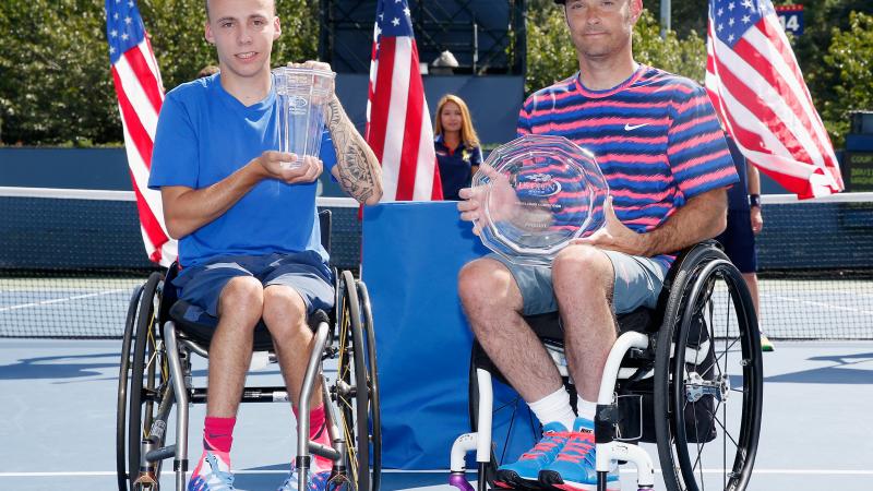 Great Britain's Andy Lapthorne (L) celebrates with the 2014 US Open trophy after defeating the USA's David Wagner (R) during the men's wheelchair quad singles final.