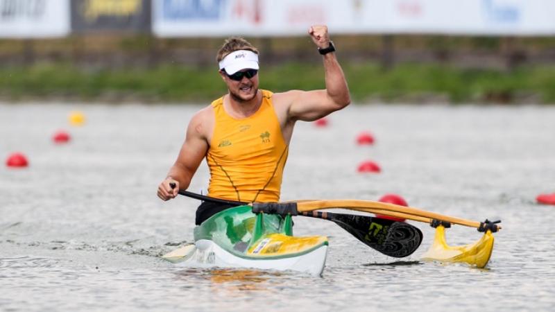 Man in canoe in triumphant pose