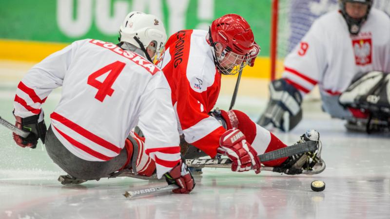 Sylwester Flis, Poland, and Martin Pachoinig, Austria, fighting for the puck in the preliminary game at the 2015 IPC Ice Sledge Hockey World Championships B-Pool in Ostersund, Sweden.