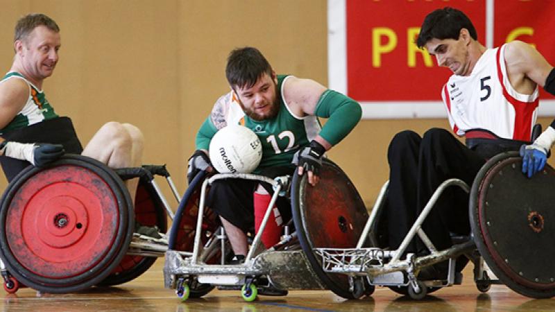 A group of male wheelchair rugby players battling for the ball