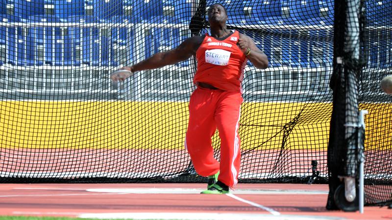 Man in red jersey throwing a discus