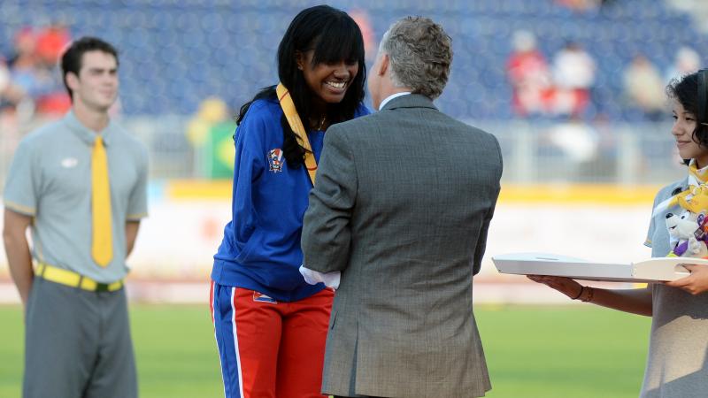Yunidis Castillo receives her gold medal for the women's 200m T47, handed over by Patrick Jarvis.
