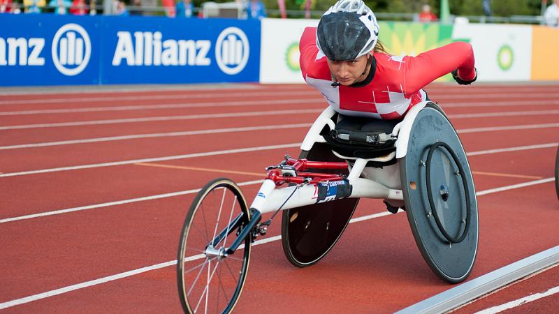 Woman in racing wheelchair competing on the track