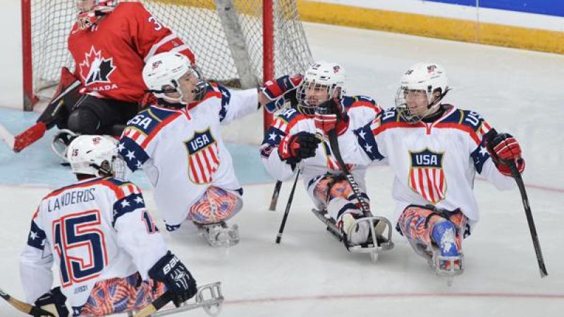 US ice sledge hockey players celebrate after a goal