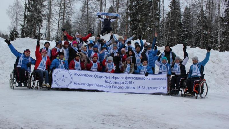 Group picture of people in wheelchairs and standing people in the snow