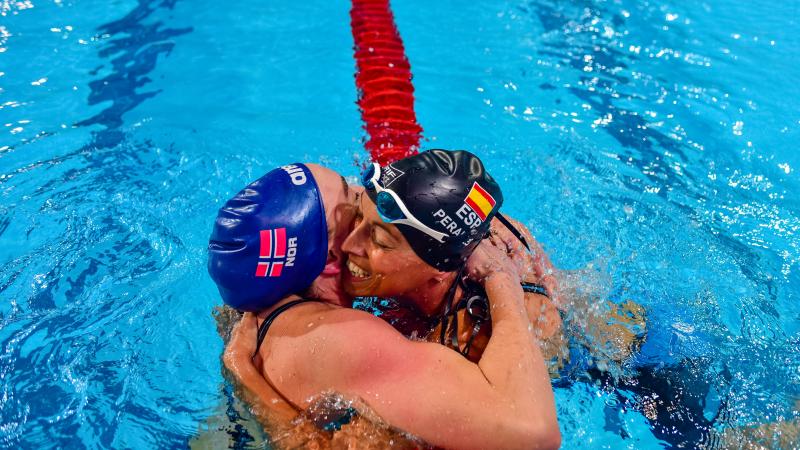 Two swimmers hugging after a race