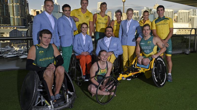 A group of 12 paralympians wearing the new green and yellow uniforms. 