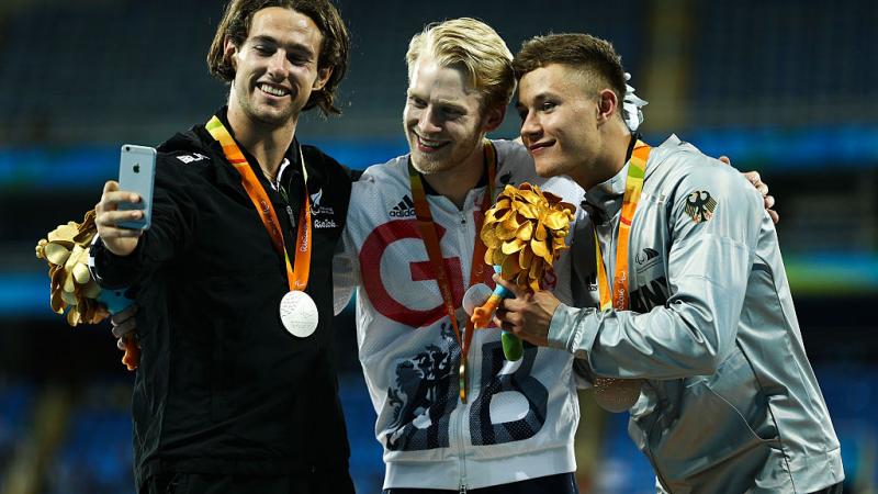 Liam Malone, Jonnie Peacock and Felix Streng take a selfie on the podium