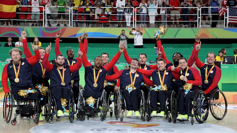 Group of men in wheelchairs celebrate after winning gold.