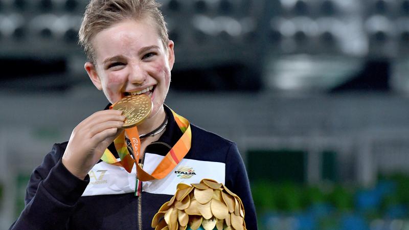 Young woman shows a medal and smiles