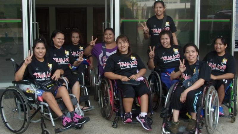 Group of Asian women's wheelchair basketball players pose 