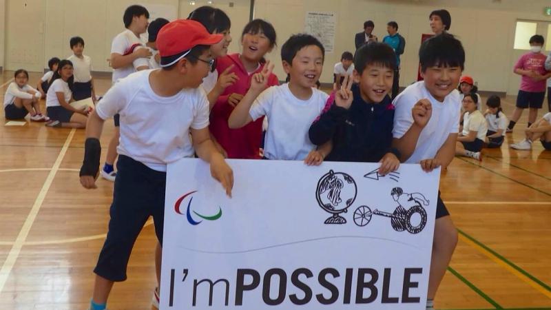 Group of Japanese kids holding up a sign