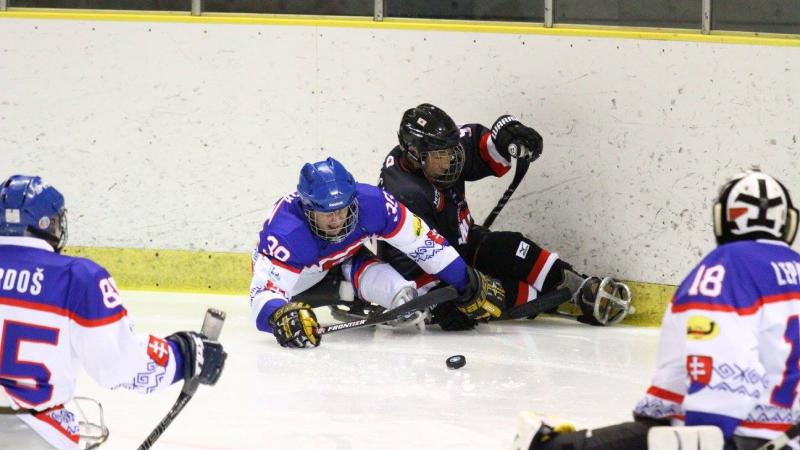 a group of para ice hockey players fight for the puck