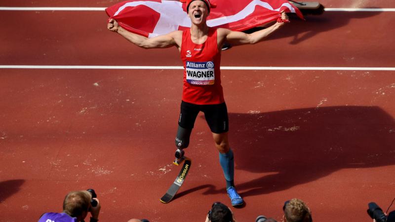 a para athlete celebrates with a flag