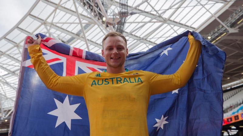 An athlete poses with the Australia flag after winning gold