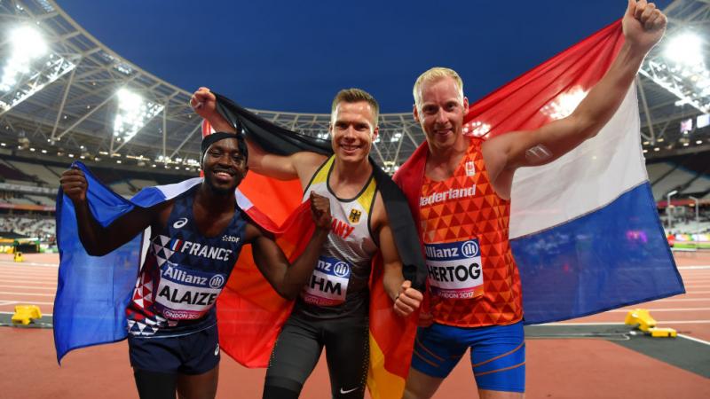 three men celebrate with the flags of their countries