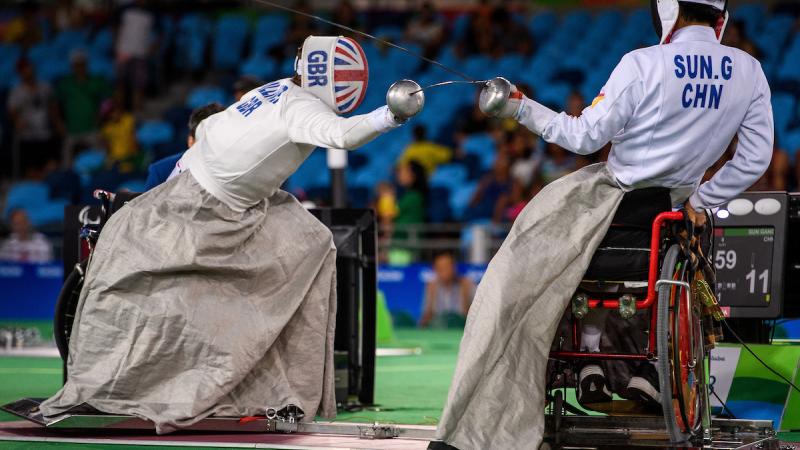 two wheelchair fencers mid bout