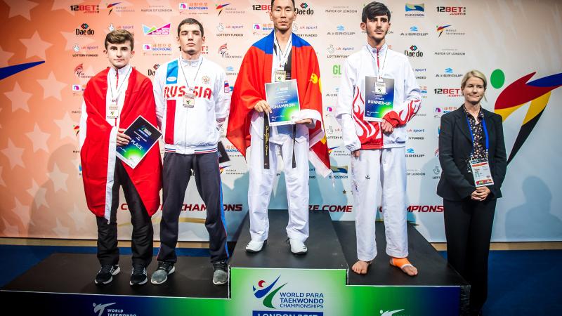 a group of Para taekwondo fighters stand on the podium