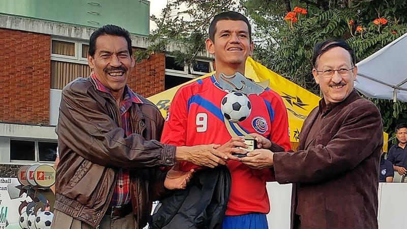 a blind footballer with his trophy 