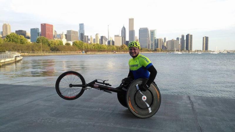 a male wheelchair racer in front of a city skyline