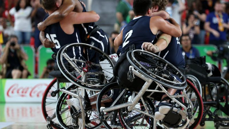 male wheelchair basketball players hug eachother on the court