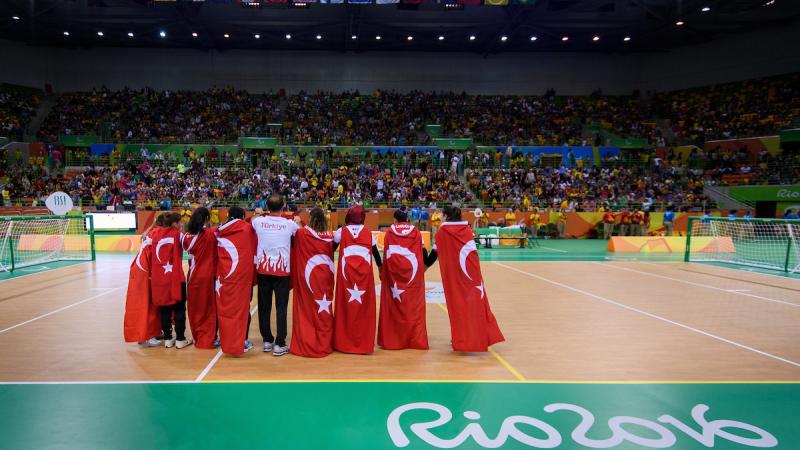a group of women hug under the Turkish flag