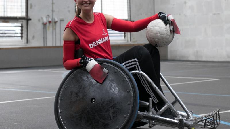 a female wheelchair rugby player poses with the ball