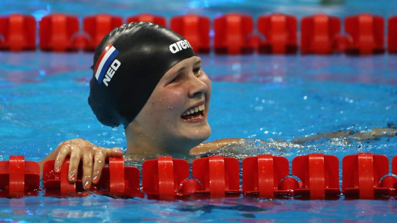 a female Para swimmer smiles in the pool