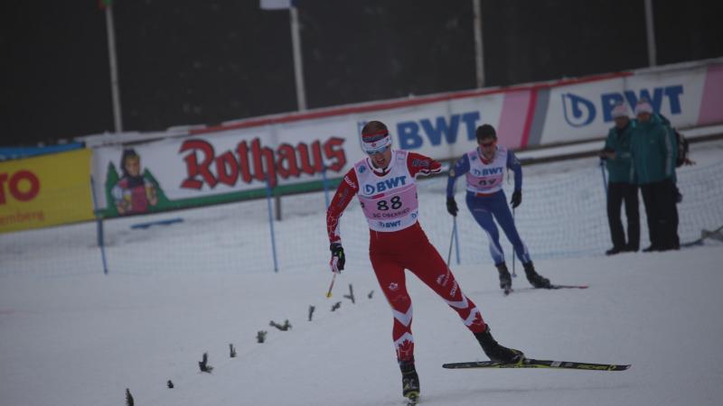 a male biathlete skies towards the finish line