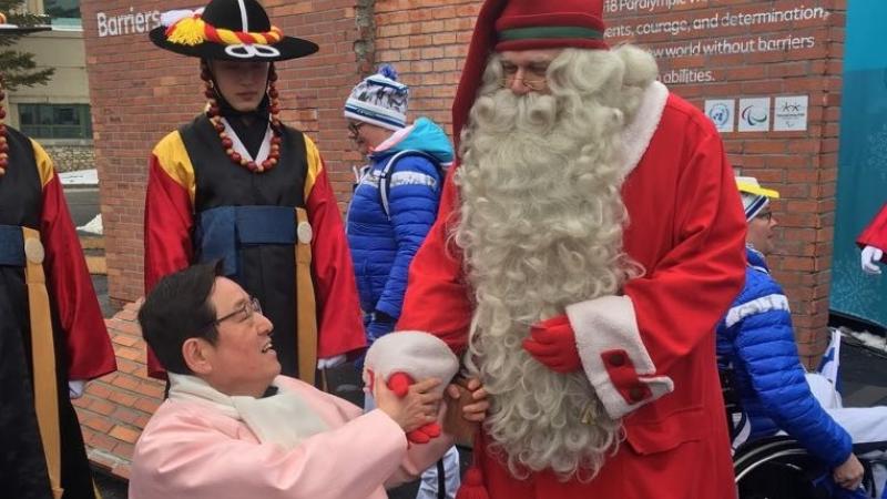 Santa Claus shaking hands with a wheelchair athlete