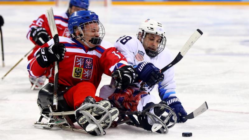 two Para ice hockey players clash on the ice