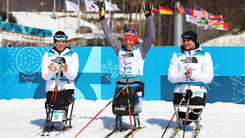 Germany's Andrea Eskau celebrates victory in the women's biathlon 10km sitting at PyeongChang 2018 with silver medallist Neutral Paralympic Athlete Marta Zainullina on the left and bronze medallist Neutral Paralympic Athlete Irina Gulaeva on the right.