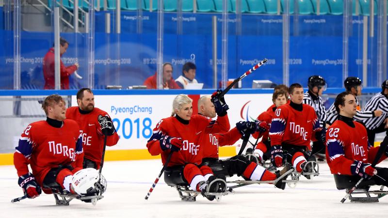 a group of Para ice hockey players celebrating the ice hockey