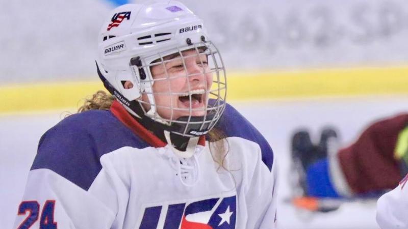 a female Para ice hockey player laughing on the ice