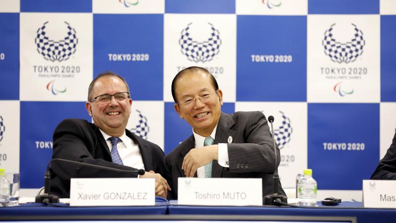 two men smiling and shaking hands
