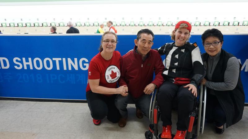 a female Para shooter hugs and smiles with her former coach