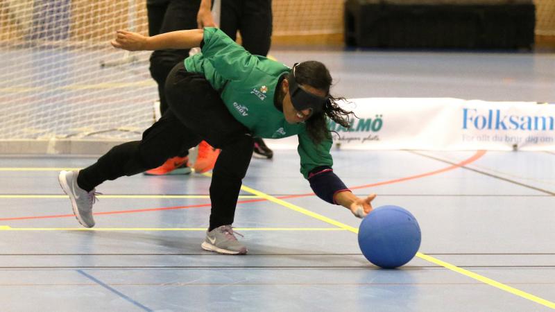 a female goalball player throws the ball