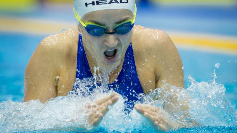 a female Para swimmer takes a breath during breaststroke