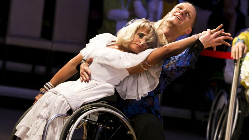 A female wheelchair dancer in a move with her able-bodied male partner