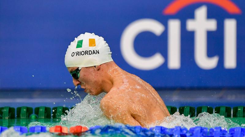 Athlete swimming with cap showing Ireland's flag