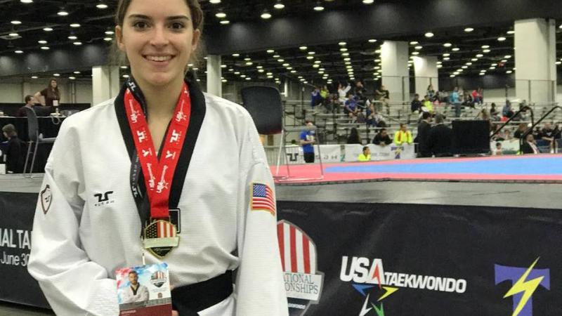 US woman taekwondo fighter poses with medal around her neck