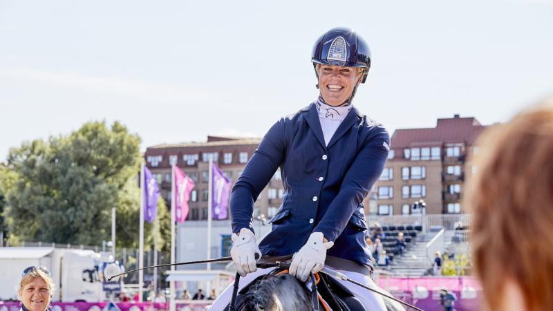 Dutch female rider smiles on her horse